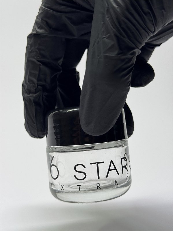 Mão com luva preta segurando um Glass Jar 6 Stars
